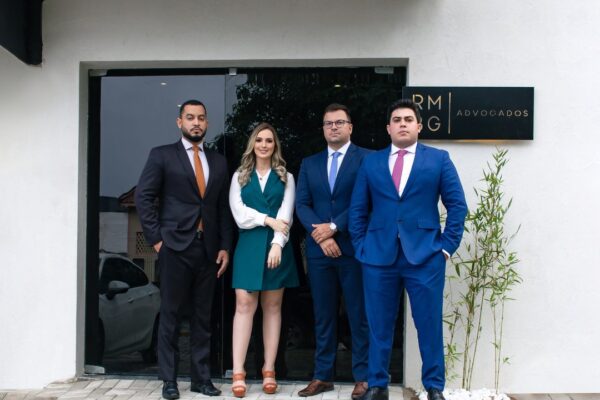 Equipe do RMBG Advogados na entrada do escritório