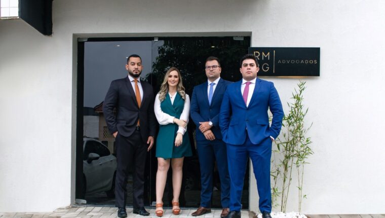 Equipe do RMBG Advogados na entrada do escritório